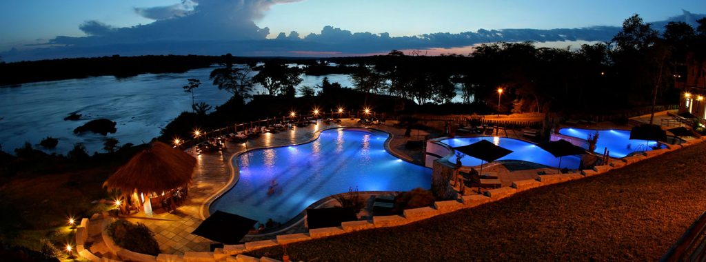 A night view of the swimming pool area at Chobe Safari Lodge, which shall be part of your experience on the 4-day luxury Murchison Falls wildlife safari.
