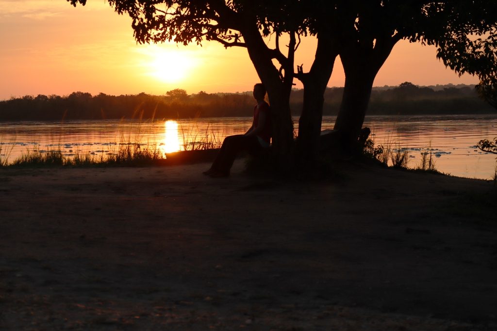 A guest hanging out to enjoy a sunset view, as part of the night game drives in Murchison Falls National Park.