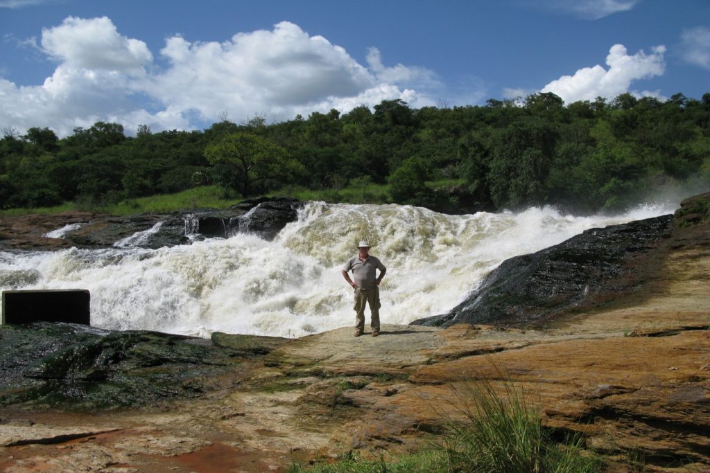 A guest enjoying photo moment at the top of Murchison Falls in Murchison Falls National Park, which is part of the 12 days Murchison Falls, Uganda & Rwanda safari